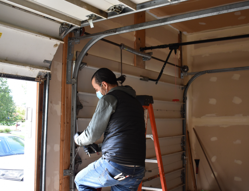 Garage Door tech fixing the spring on opener